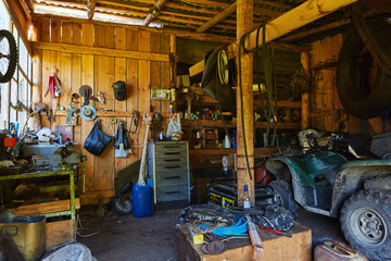 Obraz na płótnie Canvas Workshop shed garage with toold for repare and atv inside