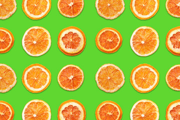 Cut orange fruit sections. Slices pattern design isolated on green background. 
