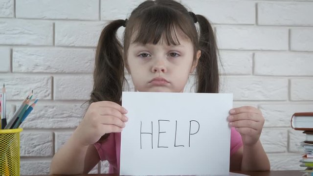 Preschooler does not want to learn. Sad little girl with a sign help me. The problem is in the education of the child.