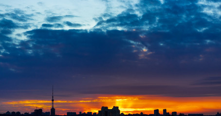 Fototapeta na wymiar dark city on orange sunset background. blue sky.
