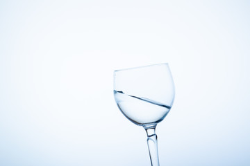 Water splashing in the luxury wine glass close up.  Concept of good healthy and refreshment.