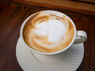 Hot latte coffe in the luxury white cup on the table close up.