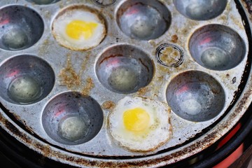 Grilled quail eggs in a pan pits