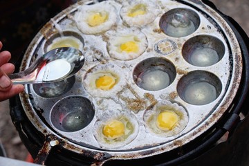 Grilled quail eggs in a pan pits