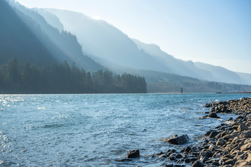 Mountain ridge illuminated by the slanting rays of the sun on the stony bank of the Columbia River...