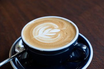 Close up of Latte art on the wood table background.
