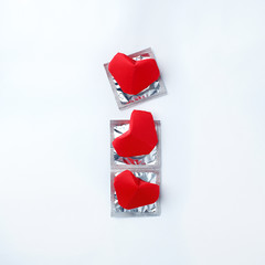 condoms and red hearts on white background. Love concept. Valentine's Day, romance event, sexual protection of health