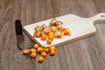 fresh golden berry (physalis) on cutting board  served on the table