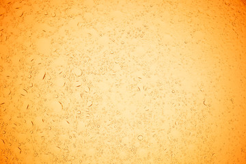 Rain droplets on yellow glass background, Water drops on yellow glass.