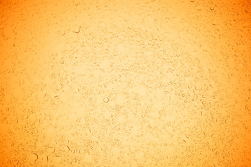 Rain droplets on yellow glass background, Water drops on yellow glass.