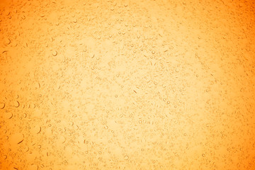 Rain droplets on yellow glass background, Water drops on yellow glass.