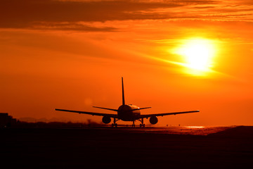 Naklejka na ściany i meble 真っ赤な夕焼け雲を飛行する航空機　Bright sunset clouds Flying aircraft