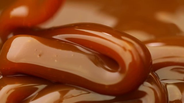 Caramel dripping thick strand. Slow motion.