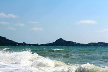 Tropical paradise - the coast with beautiful white waves against the blue sky. Thailand, Samui Island