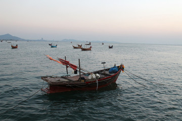 Naklejka na ściany i meble small boat in the sea and sunset sky