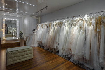 Beautiful stylish wedding dresses hanging in modern bridal salon