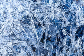 close up of dense ice crystal filled pond surface texture background on cold winter day
