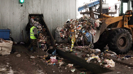 Obraz premium Workers at the waste processing plant. Sorting trash on a conveyor belt.