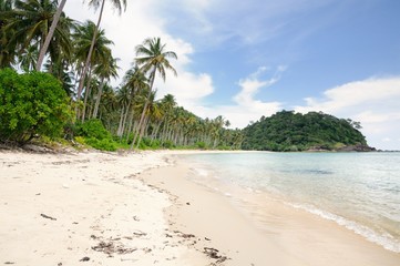 Tropical landscape with deserted amber sand beach, coconut palm trees and turquoise tropical sea on Koh Chang Island in Thailand