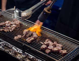 Close up hand of chef using flame torch burn on Japanese wagyu beef.