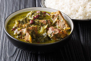 Freshly prepared Ghormeh Sabzi of lamb stew meat with herbs and beans close-up in a bowl and rice. horizontal