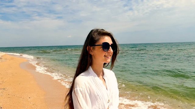 Smiling romantic girl  teenager walk on seacoast,  ocean beach. Slow motion
