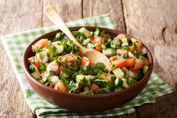 Closeup of freshly made homemade shirazi salad of cucumbers, tomatoes, onions and herbs in a bowl. horizontal