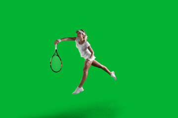 Girl tennis player on green background.