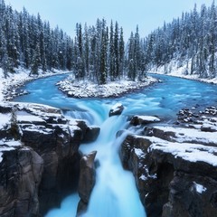 Cold scenery at Sunwapta Falls in the Canadian Rockies with snow and fir trees in wonderful scenery and ice and blue rivers running through the scenery with snowy hut. Jasper national park