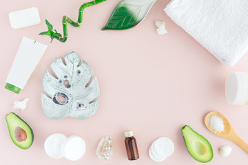 Fototapeta na wymiar Flatlay of spa cosmetic with bamboo, salt for bath, cream and towel on pastel pink background, top view mock-up