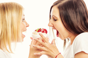 Young women eating cake, close-up, white background
