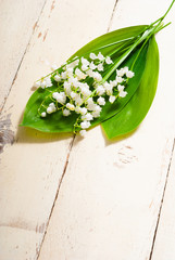 bouquet of lily of the valley flowers on old painted bright wood table background