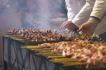 the chef prepares barbecue on the grill. traditional Caucasian dish cooked on fire.