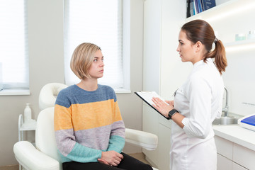 Fototapeta premium Professional woman cosmetologist in beauty clinic consulting young female client. Skin Care concept