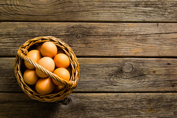 basket of eggs on old wooden background