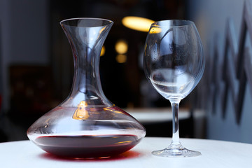 Decanter with red wine and glass on a table