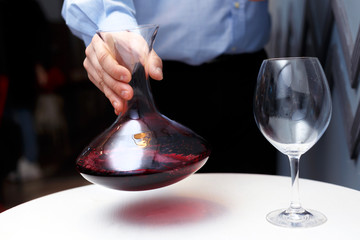 male sommelier is checking and testing red wine