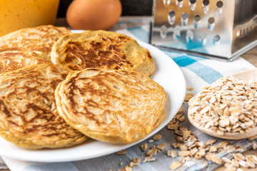 Pancakes with cheese on dark wooden background.