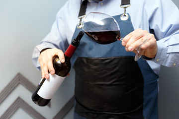 male sommelier is checking and testing red wine