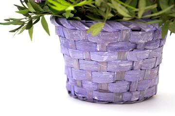 Isolated bouquet of spring flowers in decorative wicker wooden basket of lilac and purple flowers on a white background