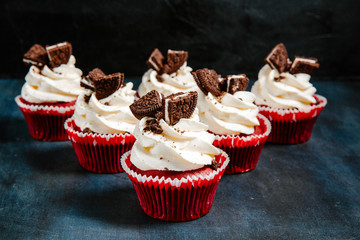 Sweet cupcakes with white cream and cookies