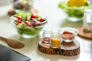 Kitchen table with salad spices and wooden spoonula