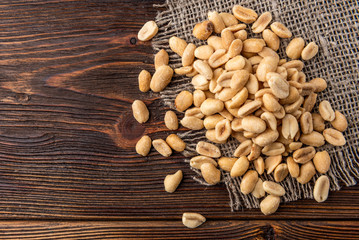 Salt peanut on dark wooden background.