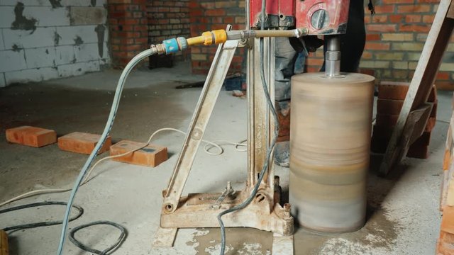 The powerful drill with a diamond tip drills holes for making communications in the house