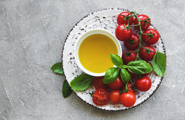 Plate with cherry tomatoes, olive oil and basil