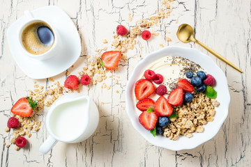 Granola for breakfast with berries, yoghurt and coffee cup. Cereal oatmeal or  muesli with...