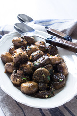Karamelisierte Champignons mit Aceto, Knoblauch, Kräutern auf einer Servierplatte