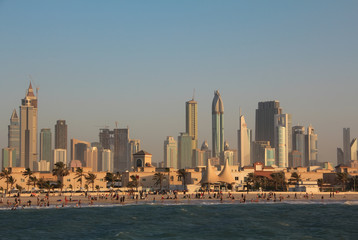 Fototapeta na wymiar Dubai downtown and people on the beach in United Arab Emirates