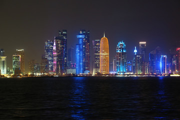  Illuminated buildings in financial centre in Doha city at night, Qatar
