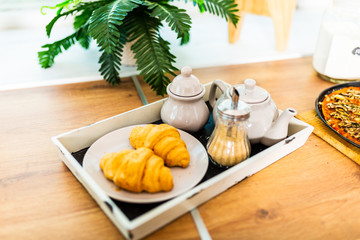 breakfast in bed with coffee, croissants, strawberries and juice